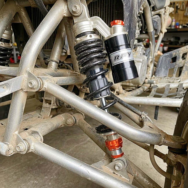Example of an installed ATV shock absorber under real-world riding conditions.